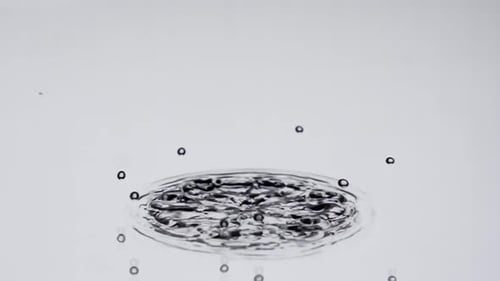 Drop of water falling and splashing in slow motion