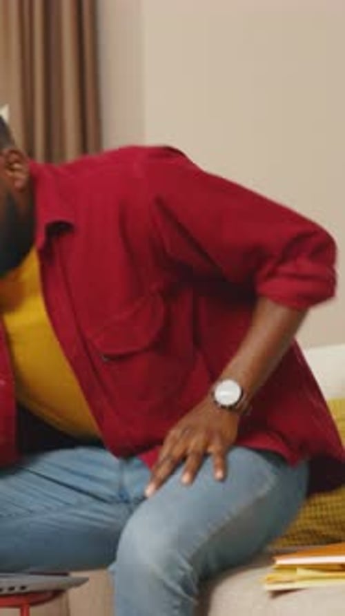 Attractive Young African American Businessman Talking on Phone Use Laptop Working From Home Office