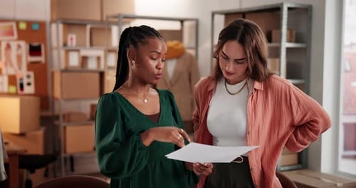 Two Young Women Reviewing Documents in an Office