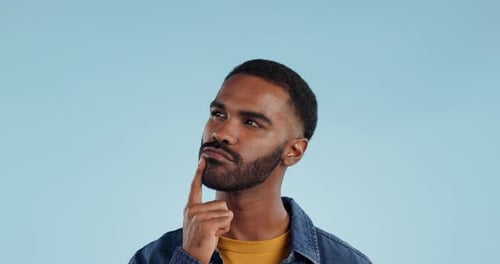 Man, thinking and planning idea with decision and choice in studio on blue background and questions