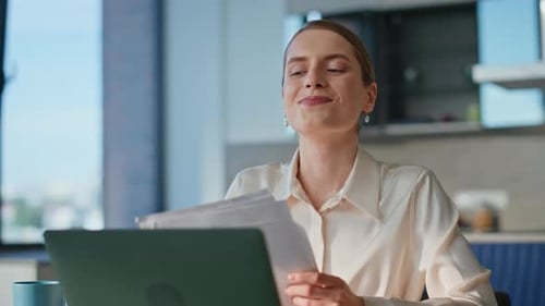 Woman Reviews Documents in Home Office Setting