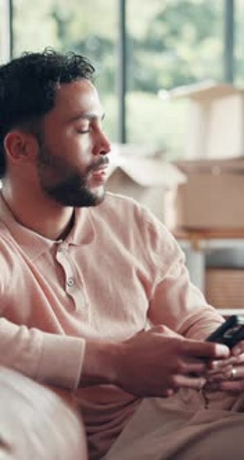 Man Using Smartphone Inside Near Moving Boxes
