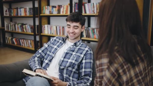 Friendly Interaction Between Two Young Adults at a Cozy Library During the Afternoon Sharing