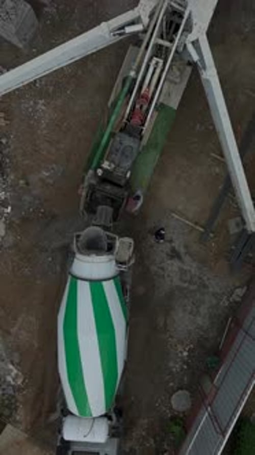 Vertical Video Active Construction Site with Workers Pouring Concrete for the Base of a Residential