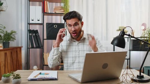 Furious Annoyed Angry Businessman Freelancer Engage in Heated Phone Quarrel Conversations at Office