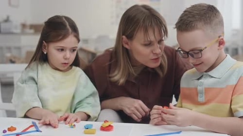 Woman and Two Children Making Clay Figures