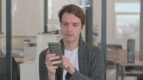 Porträt eines zufälligen jungen Mannes, der das Telefon benutzt