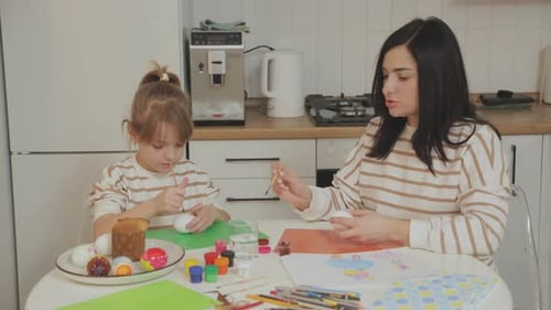 Girl and Woman Painting Easter Eggs Together