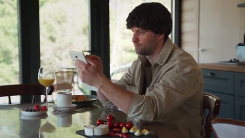 Man Using Tablet During Breakfast Indoors