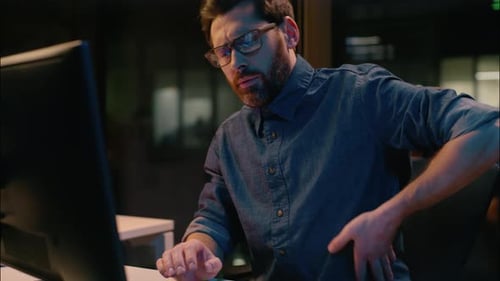 Hombre de negocios caucásico, empleador profesional, gerente en Dark Night Office, se siente sobrecargado de trabajo