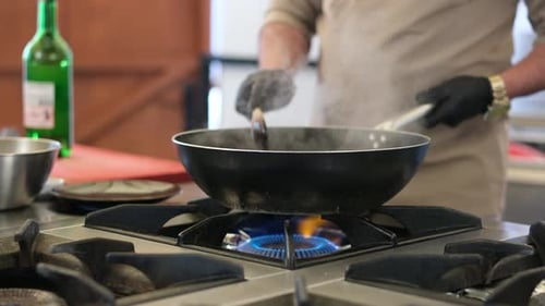 Chef cooking with frying pan and wooden spoon