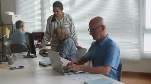 Adults Working at Desks in Modern Office