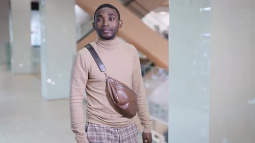 A Young African Man is Walking Through the Mall