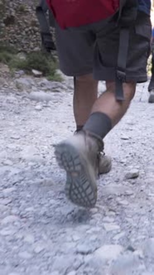 A Hiker in Hiking Boots Climbs a Mountain Ridge