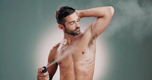 Handsome Man Sprays Deodorant on Upper Body