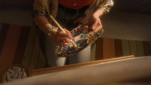 Cuadro de manos femeninas pintando sobre lienzo en casa
