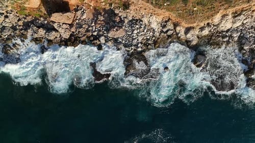 Top View of the Stone Beach in Azure Waves with White Foam Breaking Again and Again High Quality
