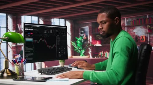 Man Reviews Financial Data at Modern Workspace