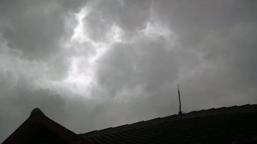 Gewitterzeitraffer am Himmel mit einem Haus im Vordergrund mit Blitzblocker.