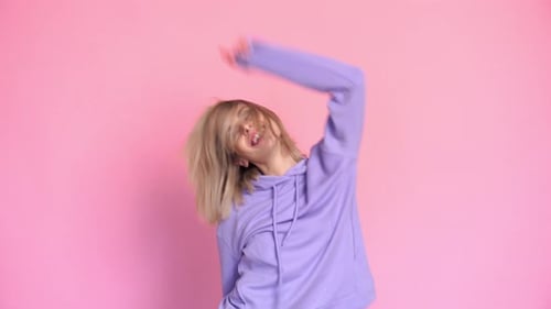 Cheerful Young Woman Dancing in Studio