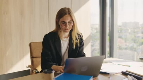 Businesswoman in Glasses and Suit Working in the Office with Important Documents and Laptop Girl