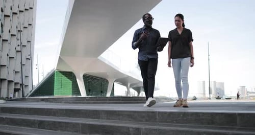 Stylish Adults Walk, Talk, and Use Tablet Outdoors