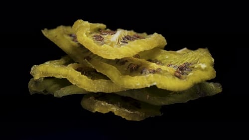 dried kiwi rotate, on a black background close-up. In move