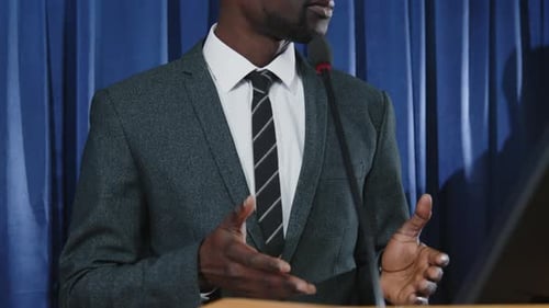 Man Giving Speech at Podium in Corporate Setting