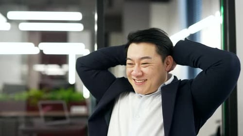 Happy asian businessman finished work on laptop sitting at workplace in business office. Satisfied