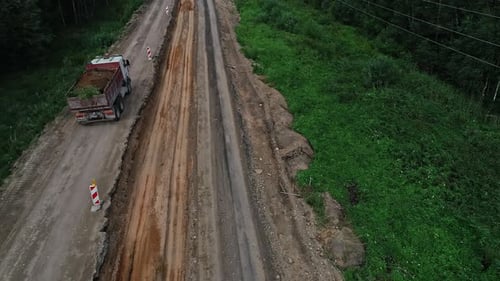 High angle shot over a white truck carrying soil after excavation work and driving away over under c