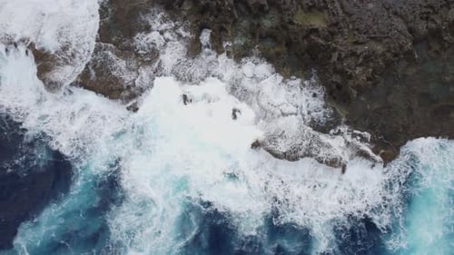Aerial view of sea waves crashing on rocks