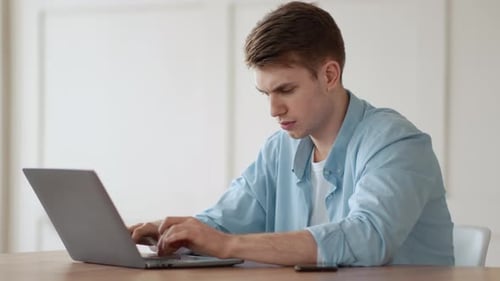 Young Frustrated Man Looking at Laptop with Error Message