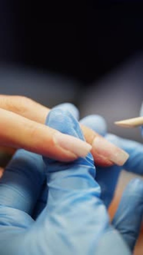 Pushing Back the Cuticle with an Orange Stick for a Manicure