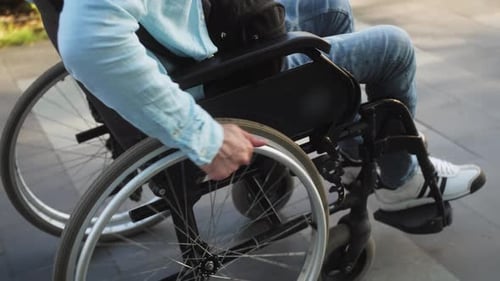 Hands Moving Wheelchair on Street Disabled Person Outdoor