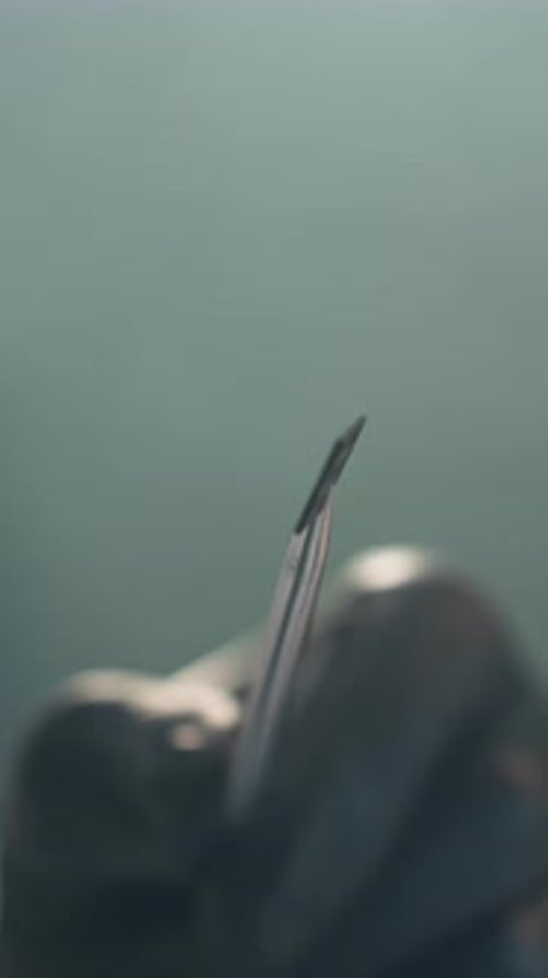 CloseUp View of Technician Examining Electronic Component with Tweezers