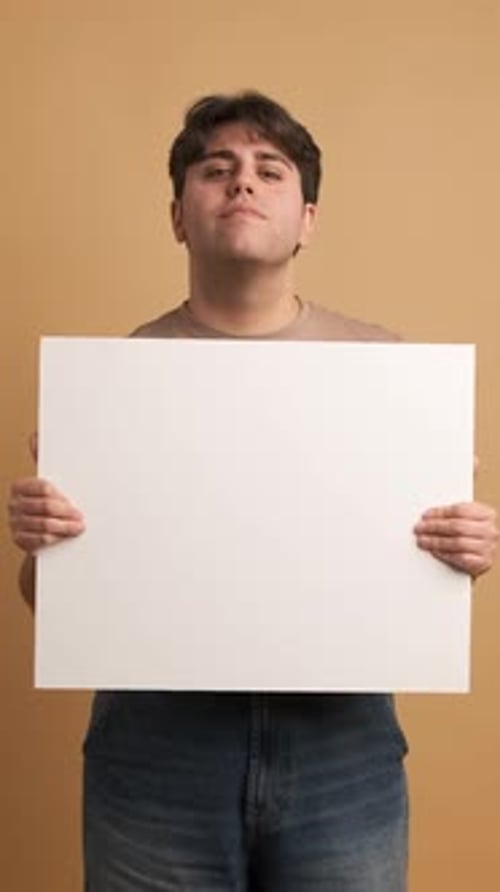 Cheerful Man Showing Blank Banner in Studio