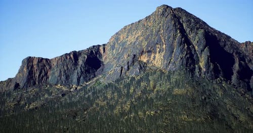 Majestic Mountain Peak Surrounded By Lush Forest in Bright Daylight