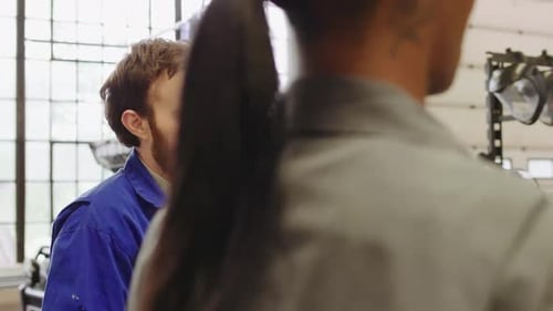 Mechanics Talking and Working in Auto Repair Shop Adult