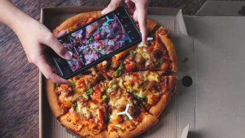 Overhead View of Pizza Being Photographed with Phone