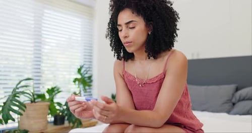 Woman, stress and anxiety in bedroom with pregnancy test with disappointed