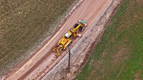 Landwirtschaftlicher Grabenbagger im Einsatz auf Feldwegen
