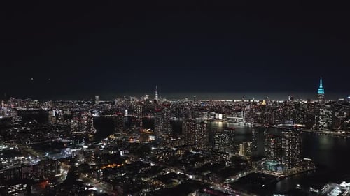 Aerial View of Queens New York City Skyline at Night Camera Pans Revealing the Empire State Building