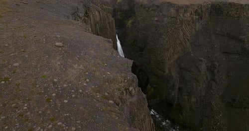 Litlanesfoss Waterfall With Basalt Columns During Snowfall In Iceland - Drone Shot