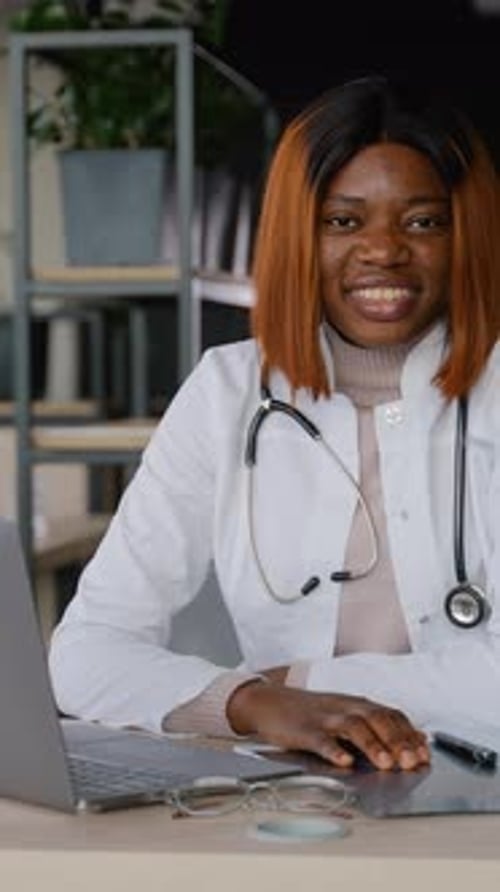 Estudiante de medicina afroamericana sonriente que estudia en la universidad