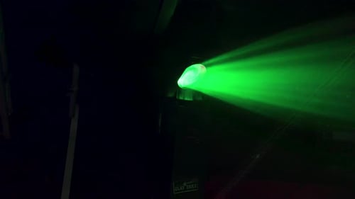 Green and blue lights moving fast in a night dance club.