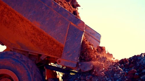 Dump Truck Unloading Red Soil on Construction Site