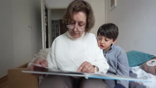 Grandmother and Grandson Reading a Picture Book on Bed