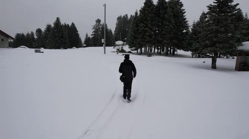 Man Walks Through Snowy Winter Forest