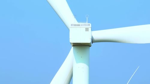 Majestic wind turbines stand tall against a soft sky, aerial view drone.