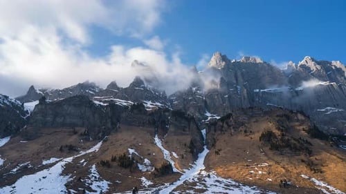 Clouds swirl at the mountain peak. Beautiful landscape timelapse